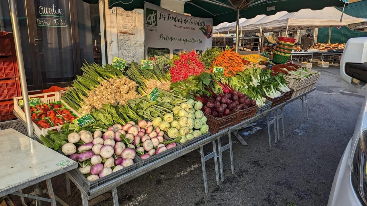 Mercado de productores con puestos de hortalizas locales