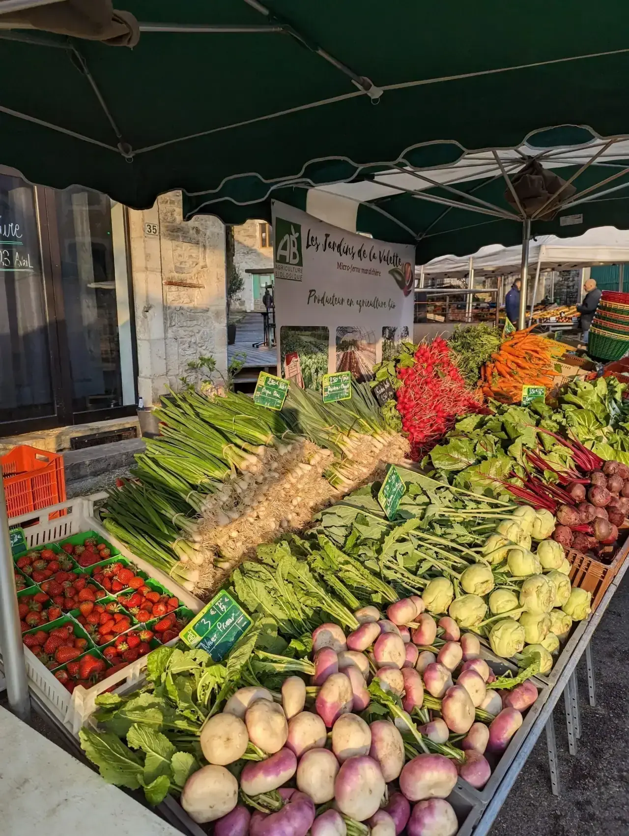 Stand de marché coloré aux Jardins de la Valette : tomates, courges et légumes de saison